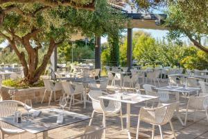 an outdoor patio with tables and chairs and trees at Hotel Osam - Adults Only in Supetar