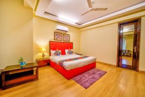 una camera con letto rosso e tavolo di FabHotel Rivlet a Gurgaon