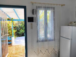 een keuken met een koelkast en een raam bij A Cretan house in the garden. in Koutsounari