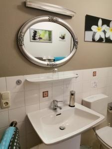 a bathroom with a white sink and a mirror at Dowis-Hof in Seebruck