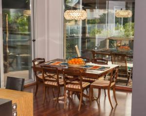 a dining room table with chairs and a bowl of oranges at Chalet de lujo in Murcia