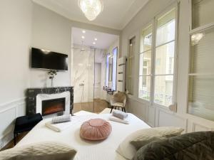 a living room with a table with a fireplace at Le Clovis Suites Spa Sauna in Reims