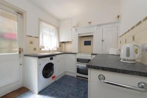 een witte keuken met een wasmachine bij The Mount 3 Bedroom Relaxation Home in Chatham