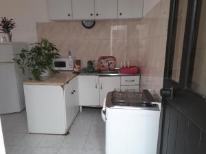 una piccola cucina con piano cottura e armadietti bianchi di Ponta Gato Residence a Tarrafal