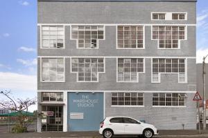 a white car parked in front of a building at Studio on Hope by HostAgents in Cape Town