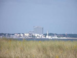 a field of grass with a city in the background at Hotel Garni Villa Ostseegruss Obje in Warnemünde