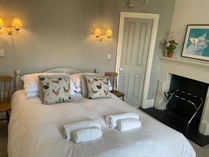 a white bed with towels on it with a fireplace at Poplars Farm in Henlow