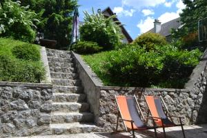 two chairs sitting in front of a stone wall at Apartments Vijolica in Kranjska Gora