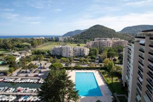 widok na ośrodek z basenem i góry w obiekcie Cannes Marina suite vue mer w mieście Mandelieu-la-Napoule