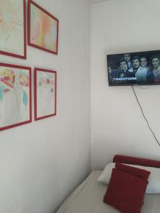 um quarto com uma televisão numa parede com fotografias em Appartamento Intero Bilocale Totalmente Arredato A Padova em Pádua