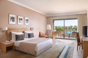 a bedroom with a bed and a television and a balcony at JAZ Little Venice Golf Resort in Ain Sokhna +18 photos