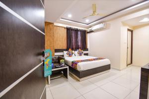 a hotel room with a bed and a window at FabHotel Rotano Suites Yelahanka in Bangalore
