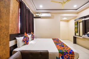una camera da letto con un letto e un divano in una stanza di FabHotel Rotano Suites - Yelahanka a Bangalore Altre 31 foto