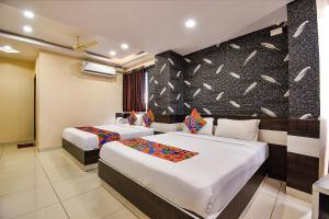 una camera d'albergo con due letti e una parete di FabHotel Rotano Suites - Yelahanka a Bangalore