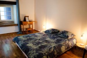 a bedroom with a bed and a table and a window at Les Genêts de la Valdaine in Rochefort-en-Valdaine