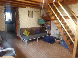 a living room with a couch and a staircase at Welshhomestead in Tregaron