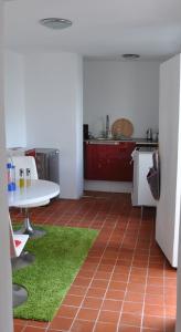 a kitchen with a white table and a green rug at Apartment in der Altstadt in Ueckermünde