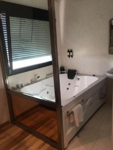 a bath tub in a bathroom with a window at Hotel Fabrik in Humanes de Madrid
