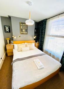 - une chambre avec un grand lit et une fenêtre dans l'établissement Ann Apartments opposite the Pier with sea view, à Portsmouth