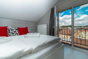 sypialnia z białym łóżkiem i dużym oknem w obiekcie Stories Hub w Lwowie