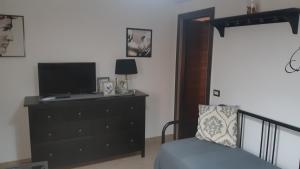 a bedroom with a bed and a television on a dresser at Mariam Holiday House in Otranto