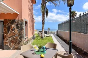 un tavolo e sedie su un patio con vista sull'oceano di Chalet Santa Ana 7 by VillaGranCanaria a Playa del Ingles