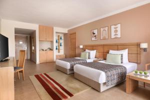 a hotel room with two beds and a television at Jaz Little Venice Golf Resort in Ain Sokhna