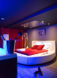 1 dormitorio con 1 cama blanca grande con almohadas rojas en Gîte Love Dream - Le Gîte Romantique, en Ger