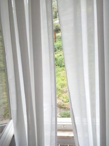 a window with white curtains in a room at CASA ADRI. Comoda, accessibile, luminosa. in Vernazza