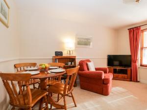 a living room with a table and chairs and a television at Derwent Haven in Keswick