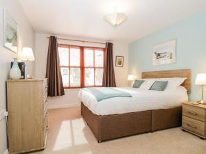 a bedroom with a large bed and a window at Derwent Haven in Keswick
