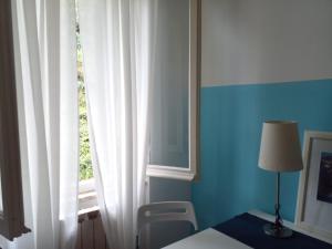 a bedroom with a bed and a window with white curtains at CASA ADRI. Comoda, accessibile, luminosa. in Vernazza