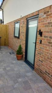 a brick building with a door and a potted plant at Petite Anchorage in Christchurch