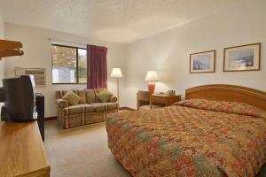 ein Hotelzimmer mit einem Bett und einem Stuhl in der Unterkunft Super 8 by Wyndham New Castle in New Castle