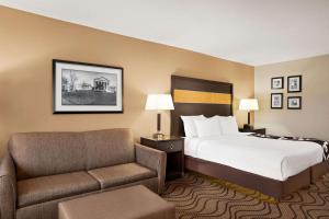 a hotel room with a bed and a couch at La Quinta Inn & Suites by Wyndham Richmond-Midlothian in Midlothian