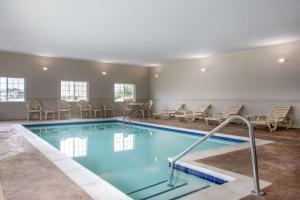 - une piscine avec des chaises et une table dans l'établissement Microtel Inn & Suites by Wyndham Liberty NE Kansas City Area, à Liberty