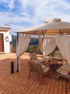 patio ze stołem, krzesłami i parasolem w obiekcie la dimora degli angeli w mieście Perugia
