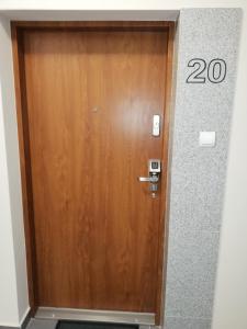 Una puerta de madera con el número. en Czerwona Cegła Apartament, en Zielona Góra