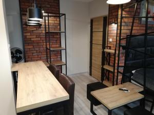 a table and chairs in a room with a brick wall at Czerwona Cegła Apartament in Zielona Góra
