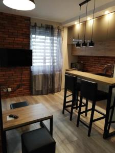 a kitchen with a table and chairs and a dining room at Czerwona Cegła Apartament in Zielona Góra