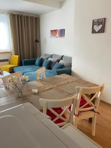 a living room with a table and a blue couch at Apartment Dony in Donovaly