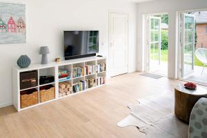 a living room with a television on a white book shelf at Das Norwegerhaus Ostsee in Graal-Müritz