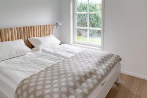 Schlafzimmer mit einem großen Bett und einem Fenster in der Unterkunft Das Norwegerhaus Ostsee in Graal-Müritz