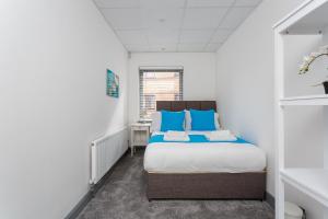 a bedroom with a bed with blue pillows at Sovereign Gate 2 - 2 bedroom apartment in Portsmouth City Centre in Portsmouth