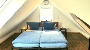 een slaapkamer met een bed met een klok aan de muur bij FRANKES CITY SLEEP Maisonette Apartment, 6 Einzelbetten in Velbert