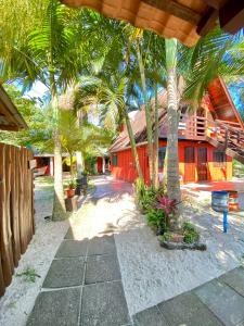 ein Resort mit Palmen und einem roten Gebäude in der Unterkunft Pousada Tia Maria in Paranaguá