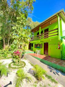 una casa verde con un camino delante de ella en Pousada Tia Maria en Paranaguá
