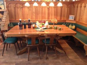 a wooden table in a room with chairs and bottles at Peterwirt in Bad Mitterndorf