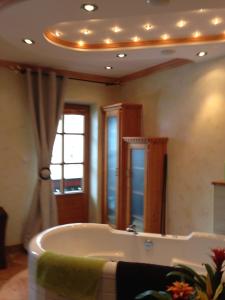 a bathroom with a tub and a large mirror at Peterwirt in Bad Mitterndorf
