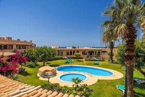 una imagen de un complejo con piscina y palmeras en Clube Maria Luisa, en Albufeira